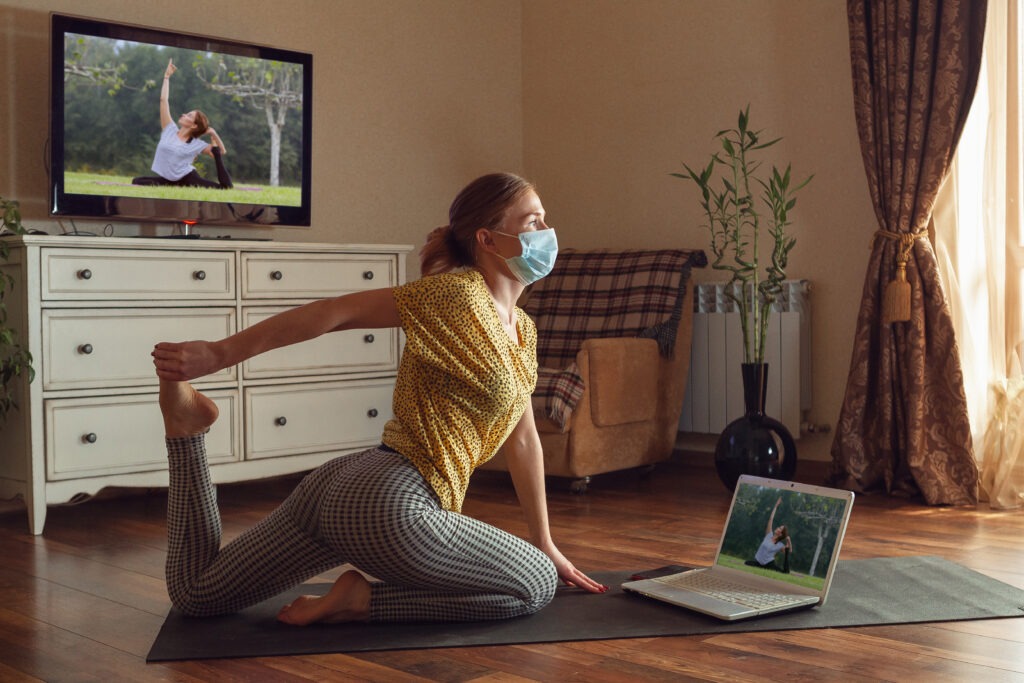 Sporty young woman taking yoga lessons online and practice at home while being quarantine Actividad rutinas y orden